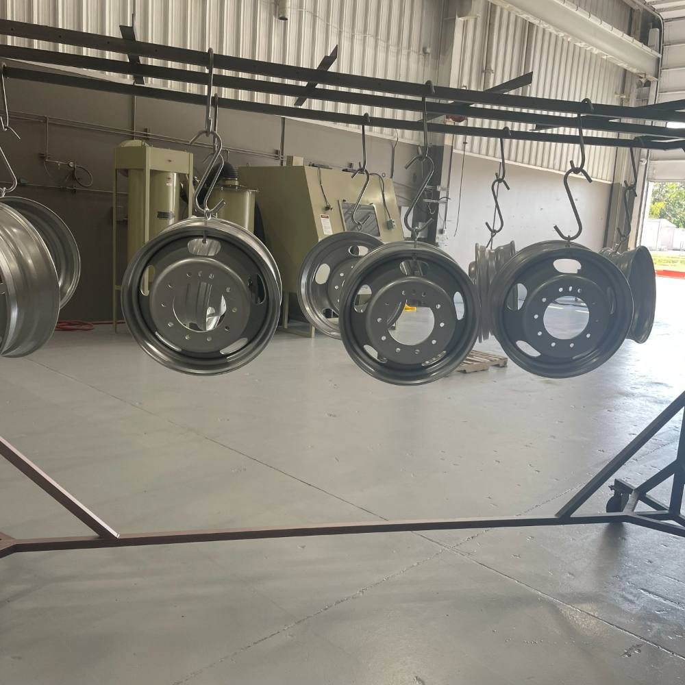 Truck wheels hanging on the line, coated and waiting to come off