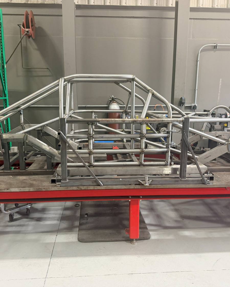 A bare chassis tacked up in its fixture on the welding table
