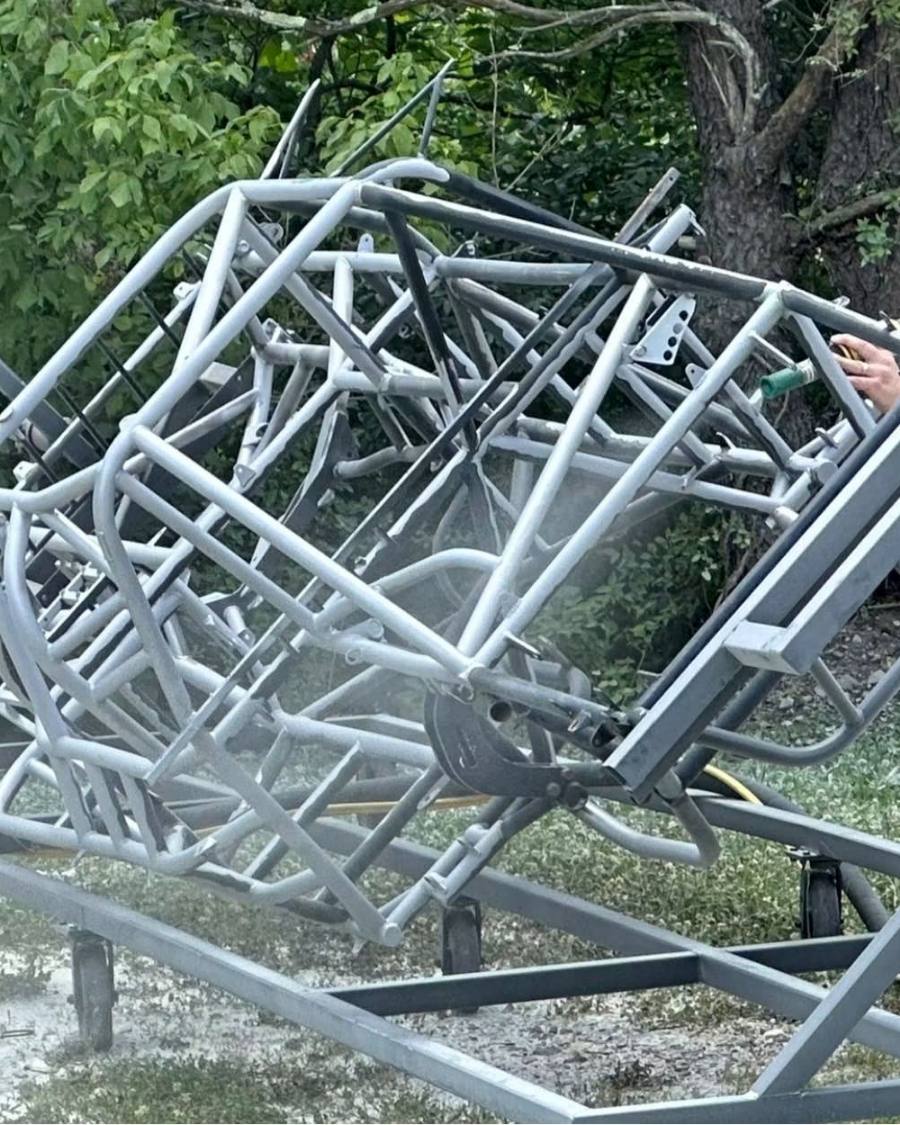 A chassis being sandblasted outside before it goes in for coating