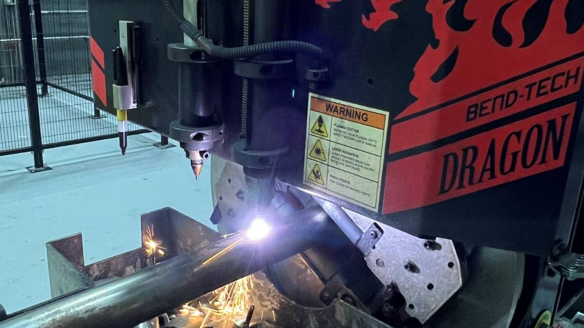 Tube being cut on the CNC plasma, sparks coming off the cut