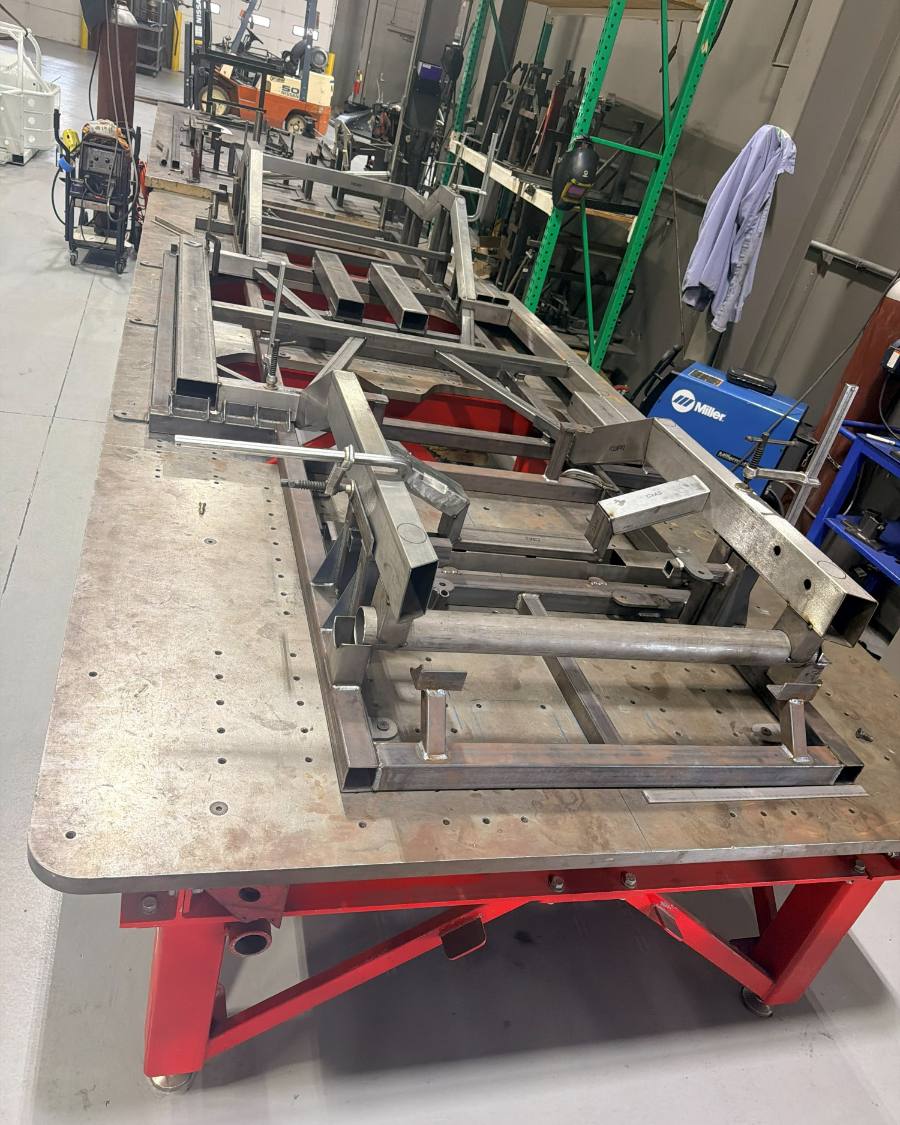 A fabricated frame clamped out flat on the welding table